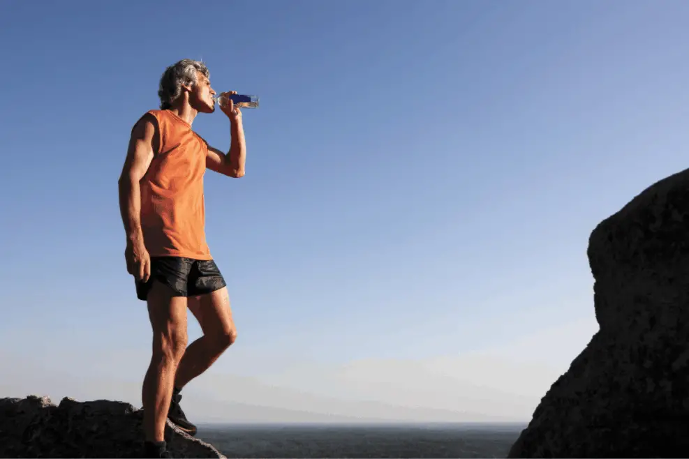man drinking water after altitude training for peak performance