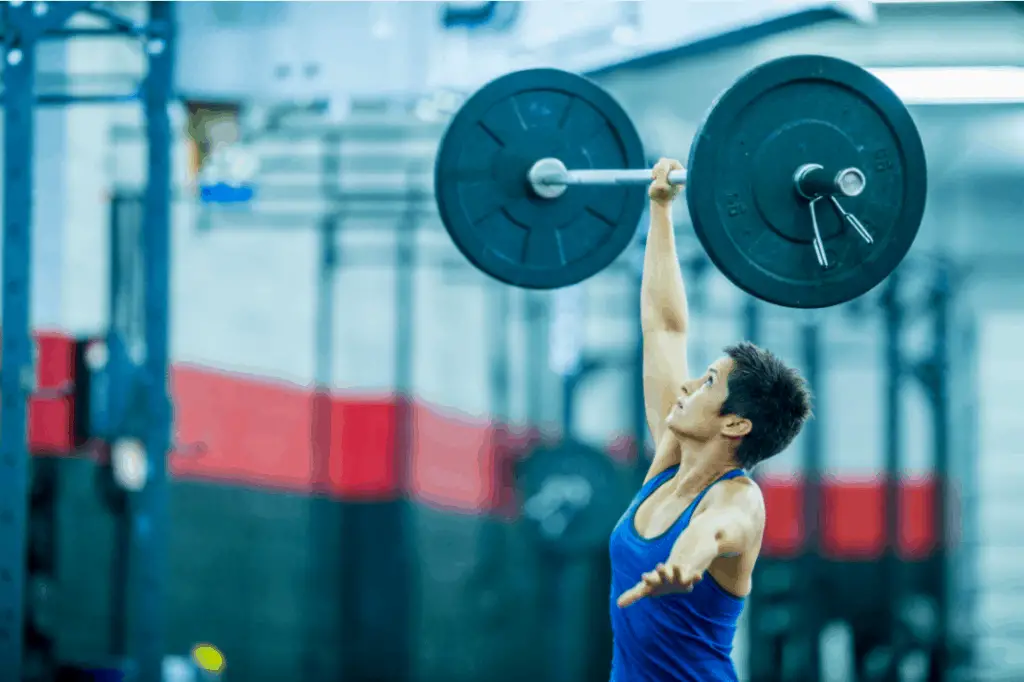 Woman single handed snatch to highlight is powerlifting good for mma